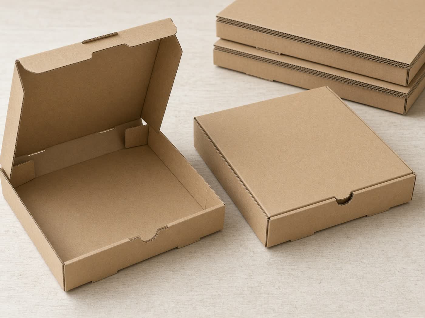 Unbranded kraft pizza boxes, one open and one closed, arranged as food-service packaging samples